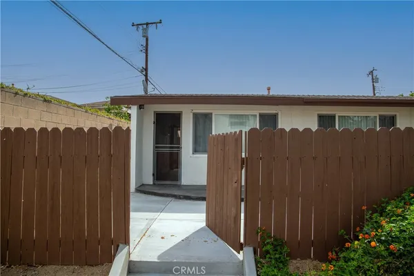 a view of a house with a wooden fence