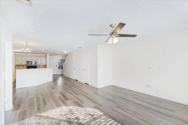 a view of a kitchen with wooden floor and a ceiling fan