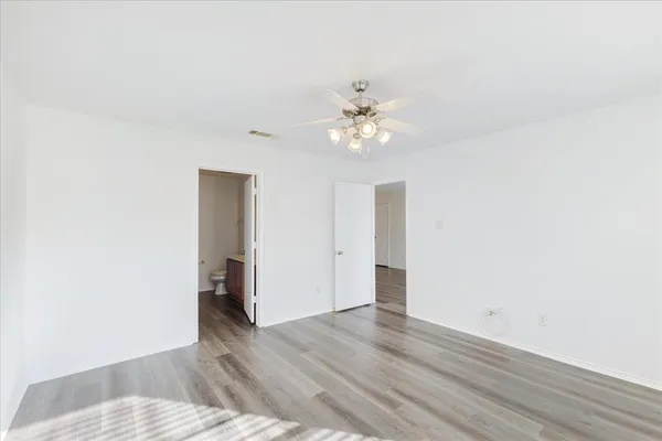 a view of an empty room with wooden floor
