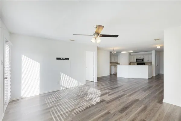 a view of a kitchen with wooden floor and a ceiling fan