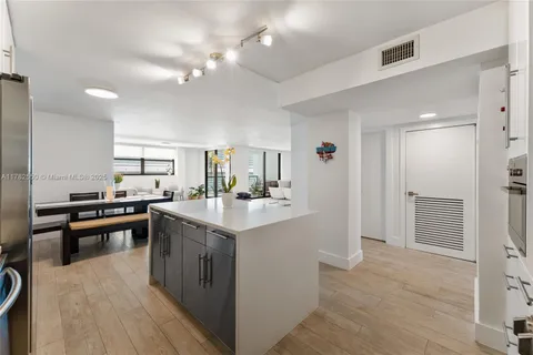 a kitchen with a sink a counter top space stainless steel appliances and cabinets