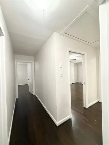 an empty room with wooden floor & windows