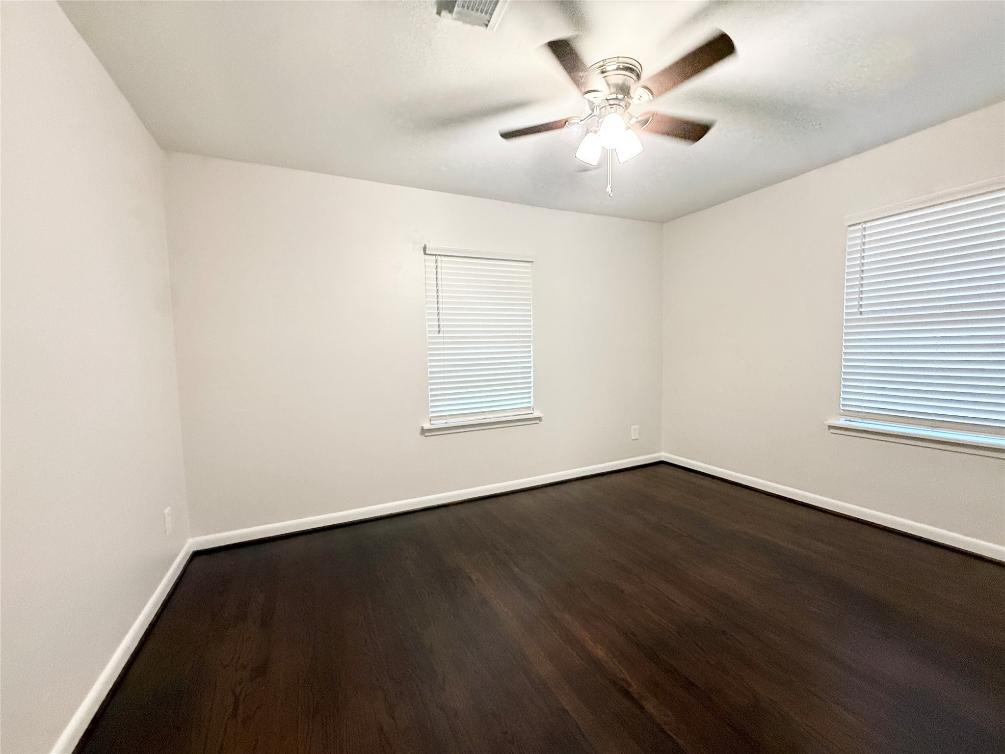 913 Wimberly Street Angleton, TX 77515 - Photo 12 of 24 an empty room with wooden floor and windows