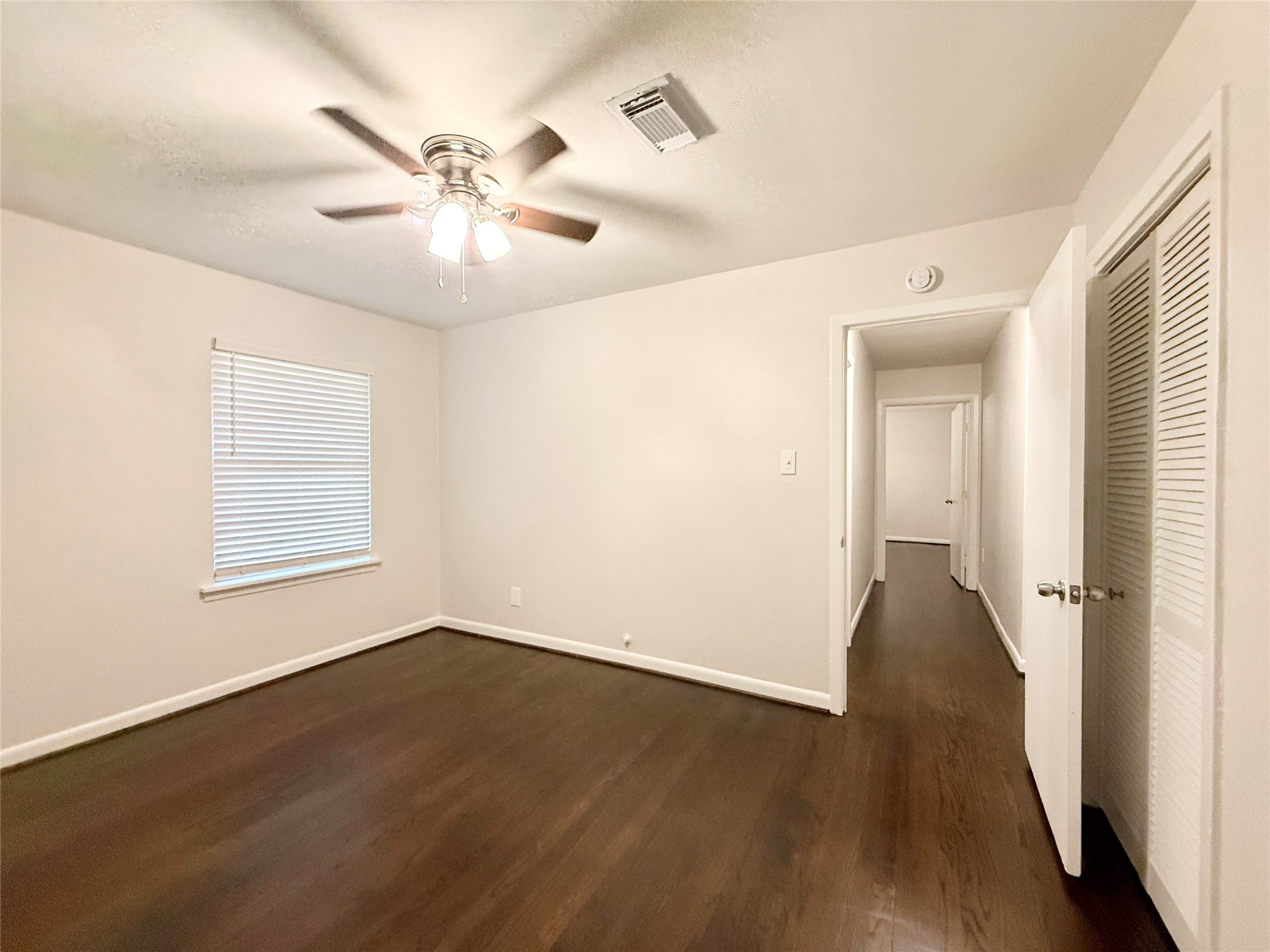 913 Wimberly Street Angleton, TX 77515 - Photo 13 of 24 an empty room with wooden floor fan and windows