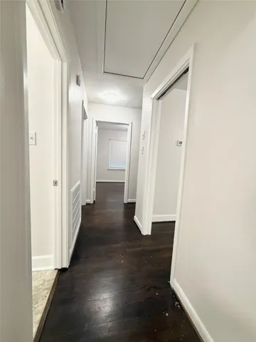 a view of a hallway with wooden floor