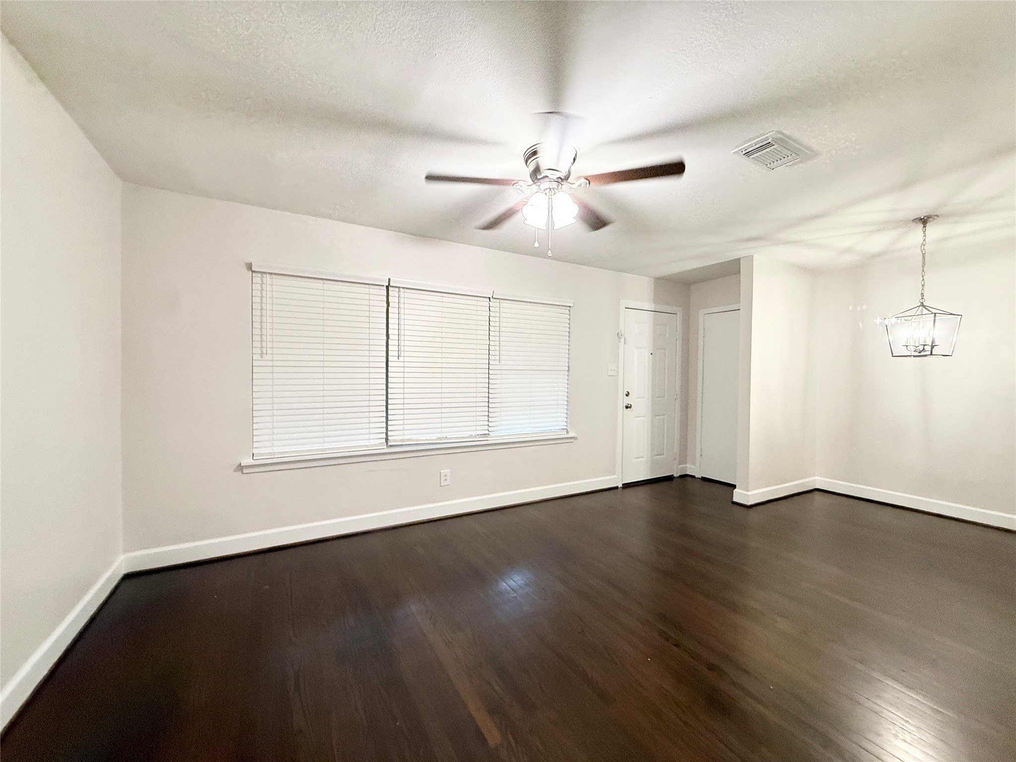 913 Wimberly Street Angleton, TX 77515 - Photo 2 of 24 a view of an empty room with wooden floor and a window