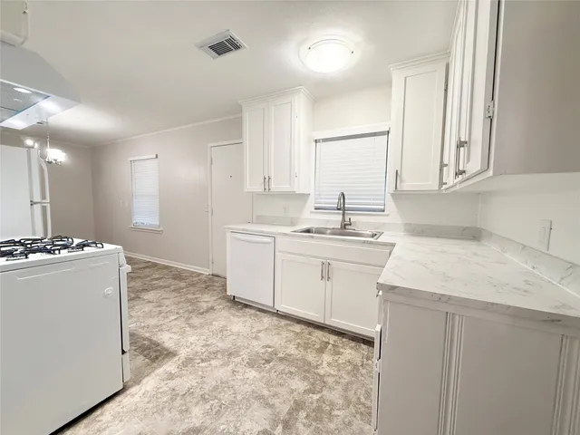 a kitchen with a sink stove and white cabinets