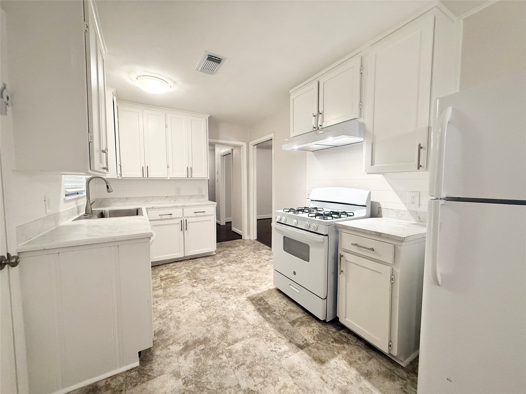 913 Wimberly Street Angleton, TX 77515 - Photo 7 of 24 a kitchen with white cabinets and white appliances