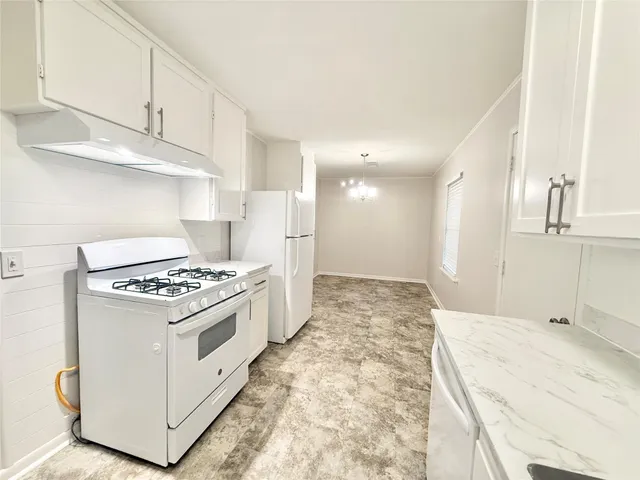 a kitchen with stainless steel appliances granite countertop a stove and a refrigerator