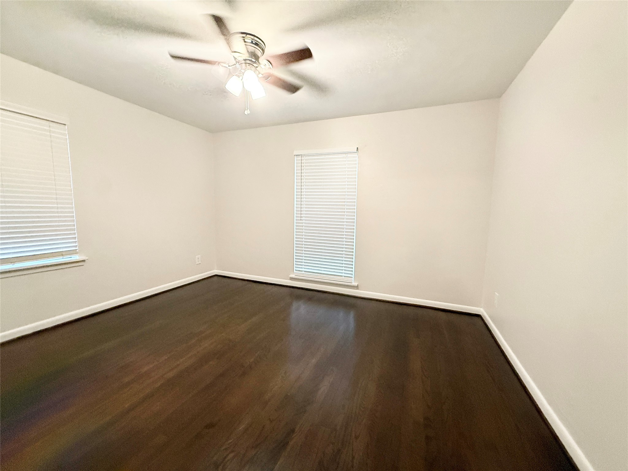 913 Wimberly Street Angleton, TX 77515 - Photo 9 of 24 an empty room with wooden floor and fan