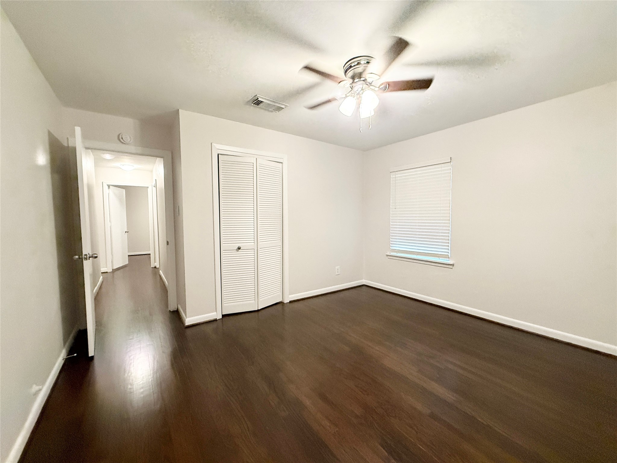 913 Wimberly Street Angleton, TX 77515 - Photo 10 of 24 an empty room with wooden floor fan and windows