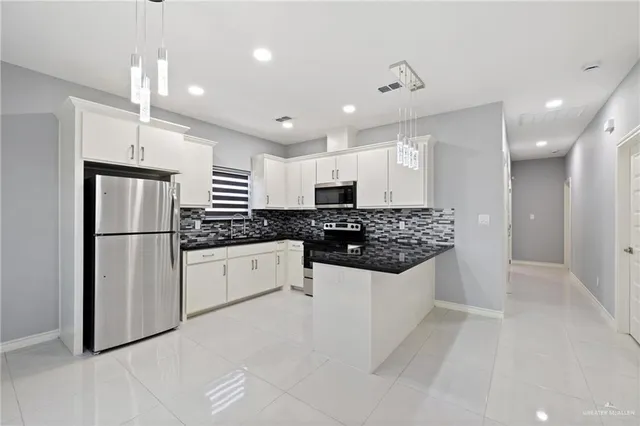 a kitchen with a refrigerator a sink and cabinets