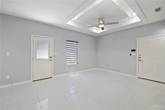 an empty room with windows and fan