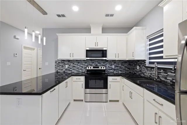 a kitchen with stainless steel appliances granite countertop a sink and a stove