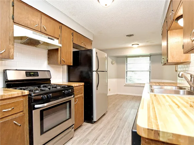 a kitchen with a stove a refrigerator and a sink