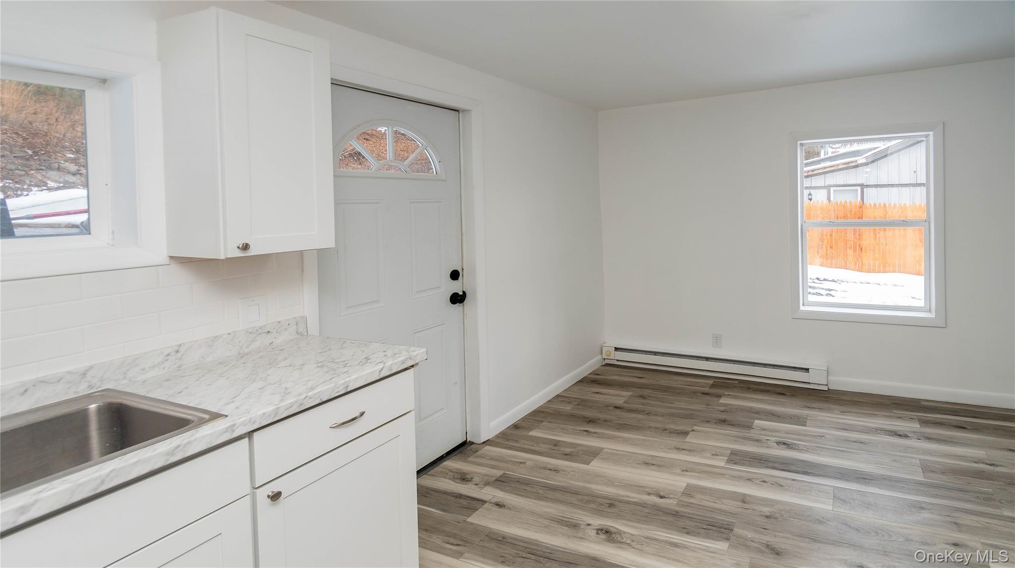 112 State Rte 55 Napanoch, NY 12458 - Photo 20 of 42 Kitchen with white cabinets, baseboard heating, light wood-style floors, and light stone countertops
