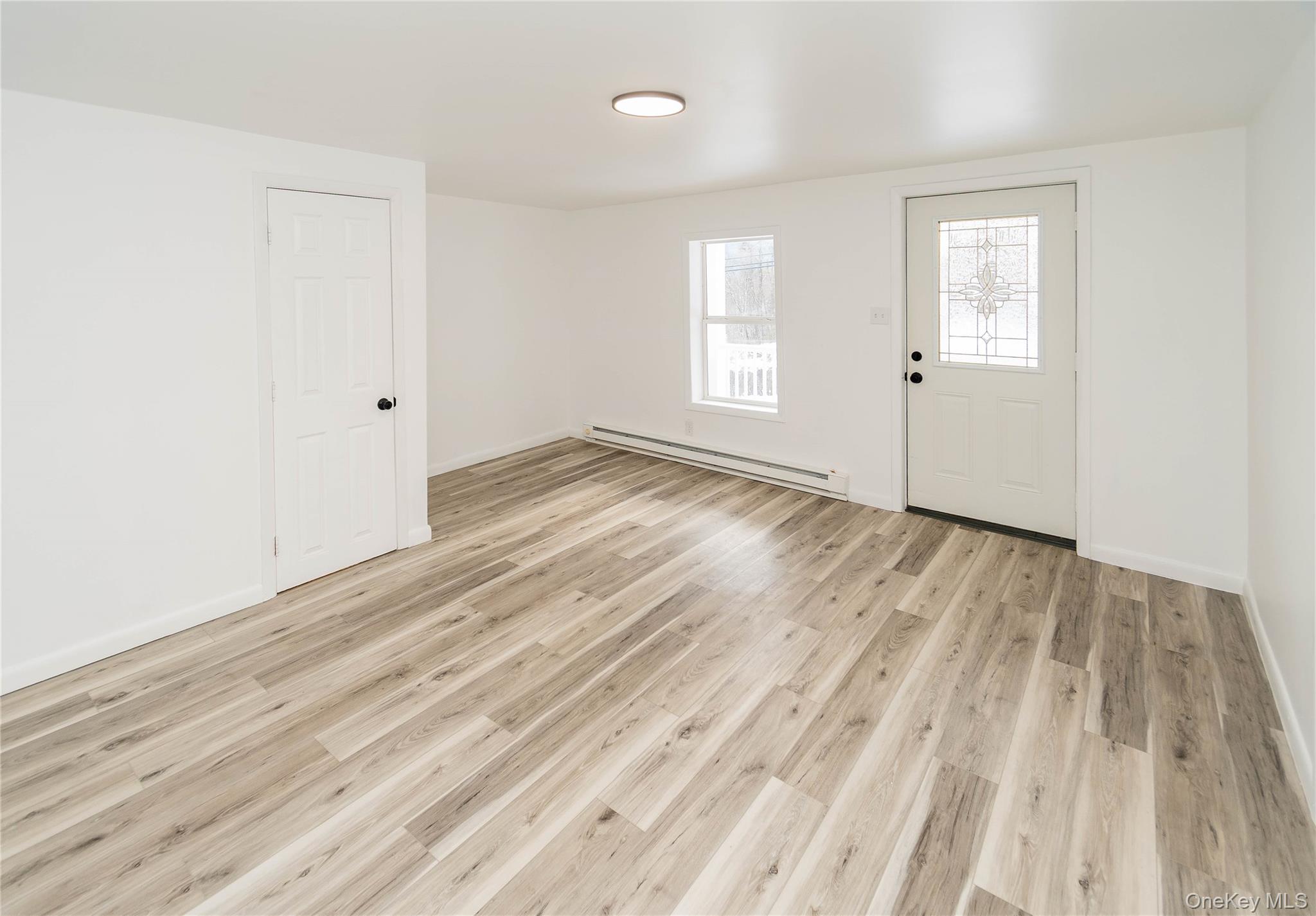 112 State Rte 55 Napanoch, NY 12458 - Photo 9 of 42 an empty room with wooden floor and windows
