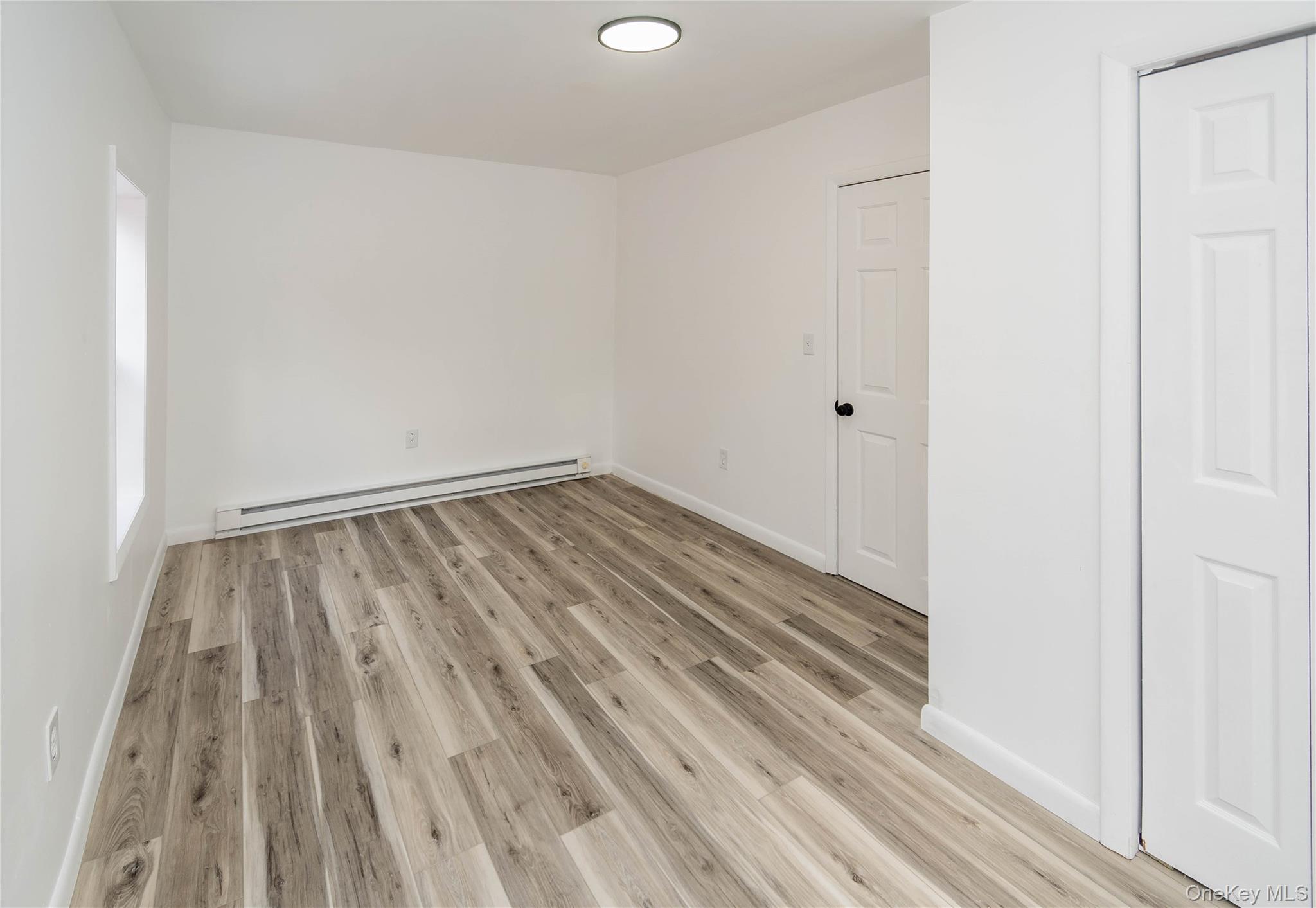 112 State Rte 55 Napanoch, NY 12458 - Photo 10 of 42 Unfurnished bedroom featuring baseboard heating and light wood-style flooring