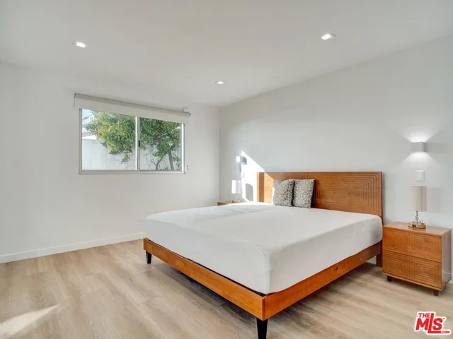 a large bed sitting in a bedroom next to a window