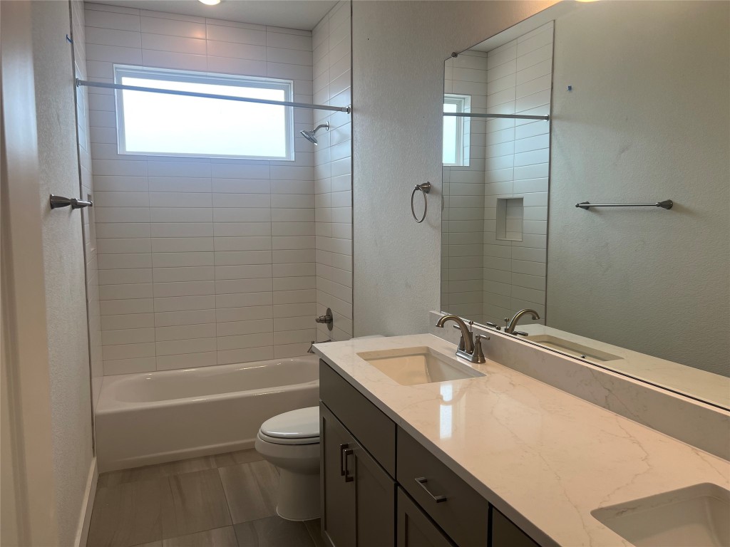 1507 Corsac Way Austin, TX 78758 - Photo 12 of 14 a bathroom with a granite countertop sink a toilet and shower