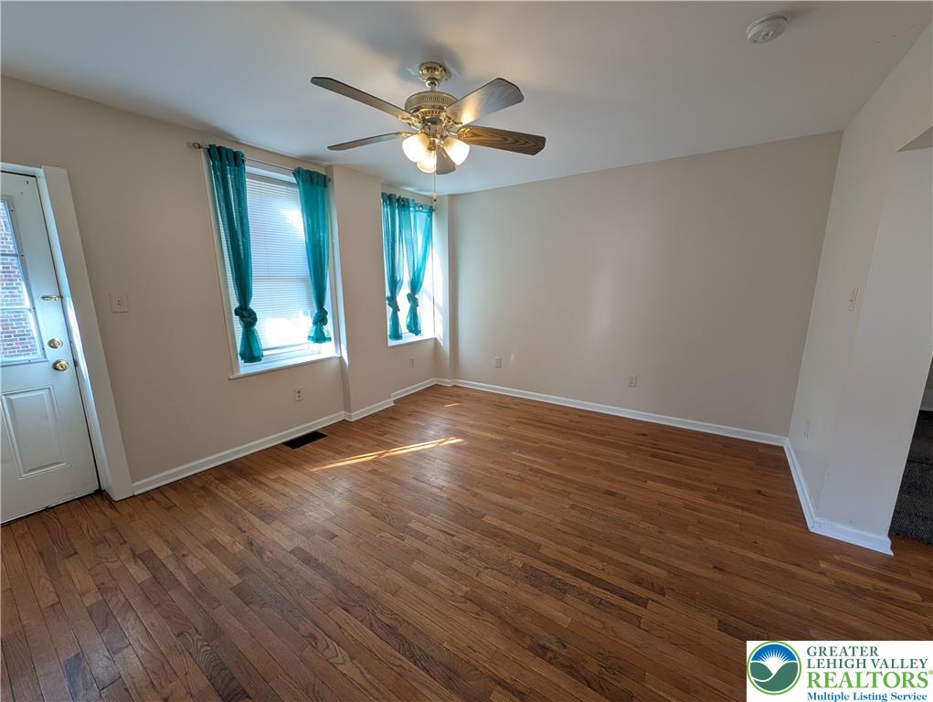723 Chestnut Street Allentown, PA 18102 - Photo 3 of 25 a view of an empty room with wooden floor and a window
