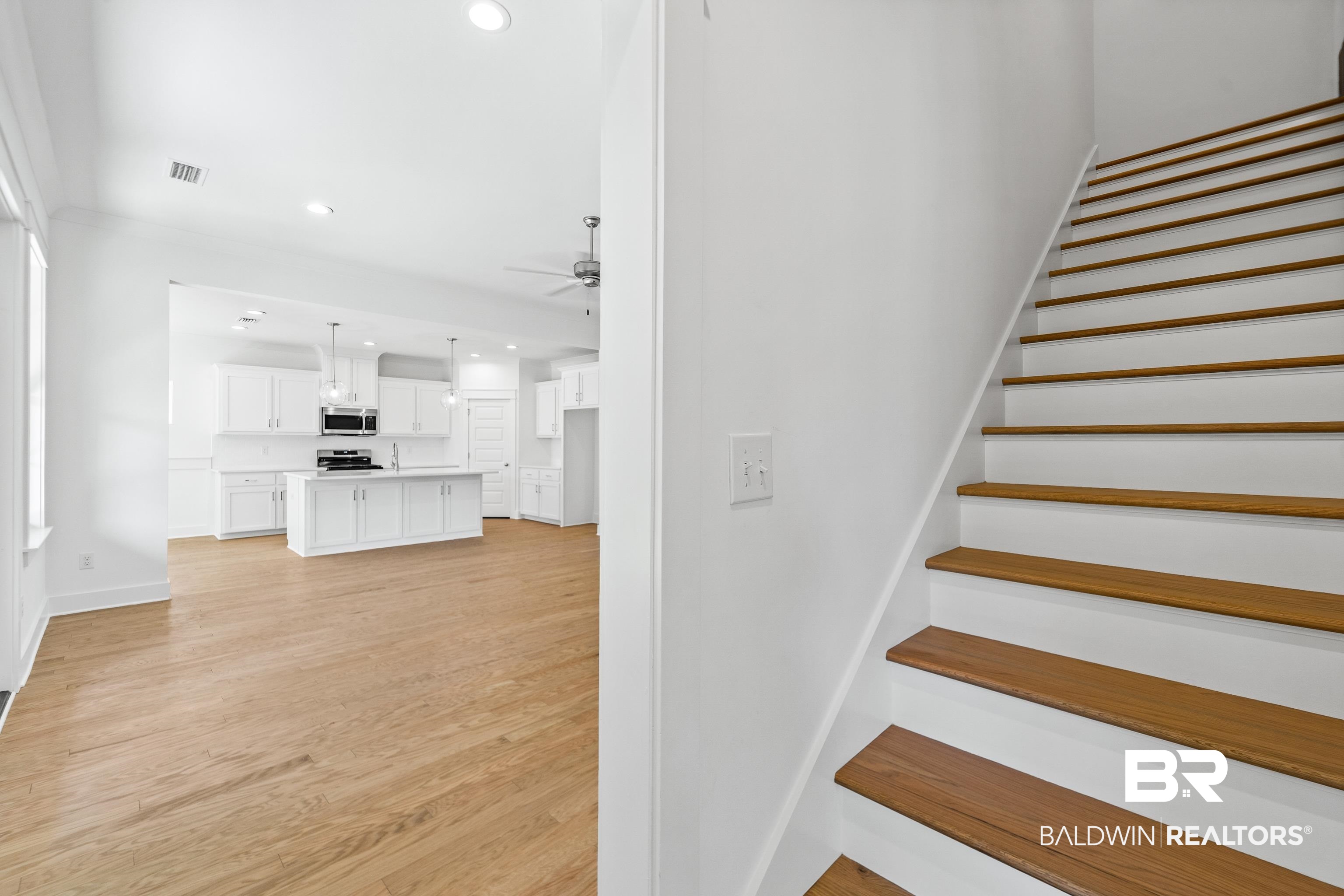 25927 Capra Court Daphne, AL 36526 - Photo 15 of 37 Stairs with ceiling fan and hardwood / wood-style floors