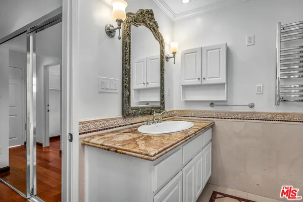 a bathroom with a granite countertop sink and a mirror