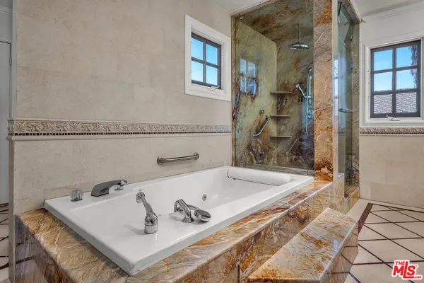 a bath tub sitting next to a white sink and a shower