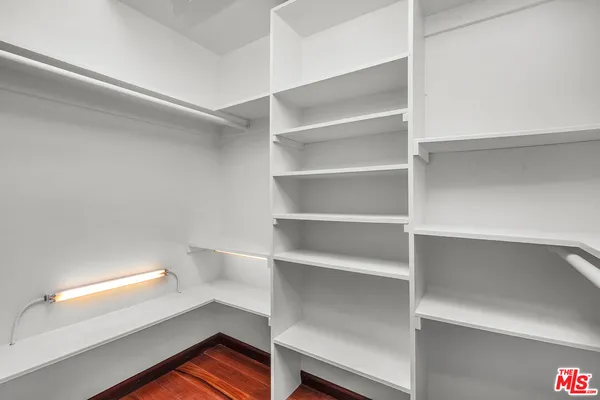 a view of walk in closet with empty racks