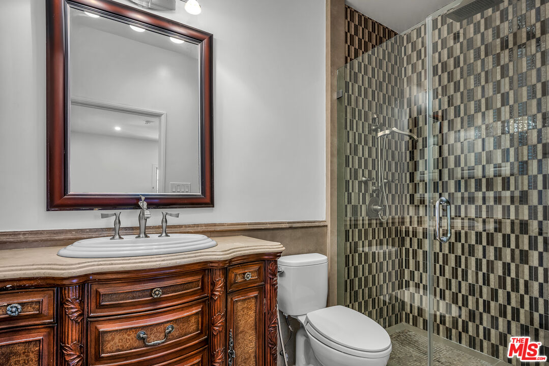 10810 Rochester Avenue Los Angeles, CA 90024 - Photo 26 of 33 a bathroom with a granite countertop toilet sink and mirror