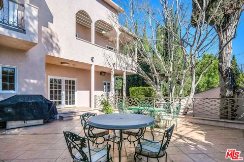 a view of a house with backyard and sitting area