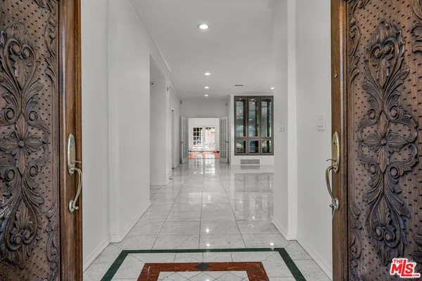 a view of a hallway with a dining table and chandelier