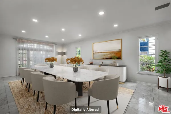 a kitchen with stainless steel appliances granite countertop a dining table chairs and a refrigerator