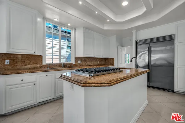 a kitchen with granite countertop a sink stove and refrigerator