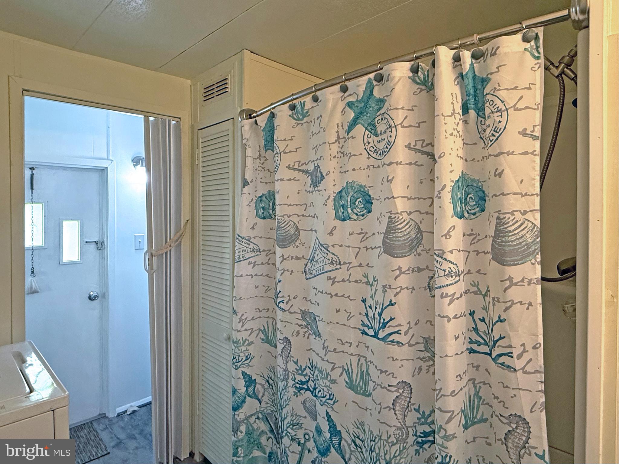 38306 Squirrel Road, Unit 217 Ocean View, DE 19970 - Photo 11 of 28 a bathroom with a shower curtain and a shower curtain