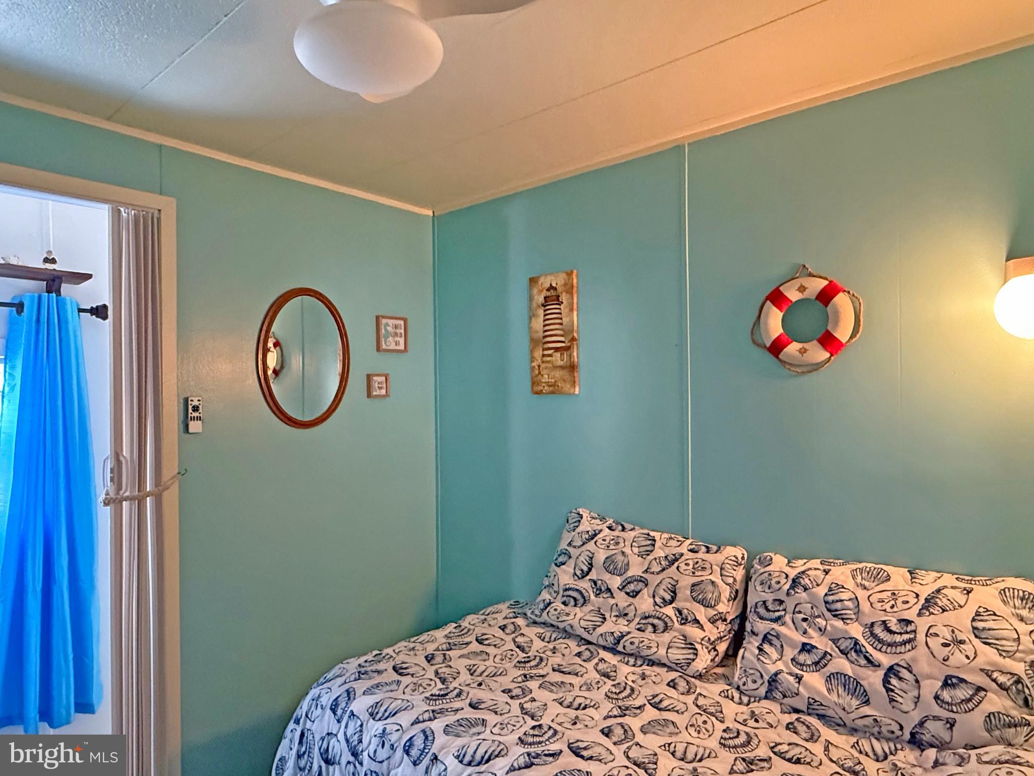 38306 Squirrel Road, Unit 217 Ocean View, DE 19970 - Photo 14 of 28 a bedroom with a bed and a chandelier