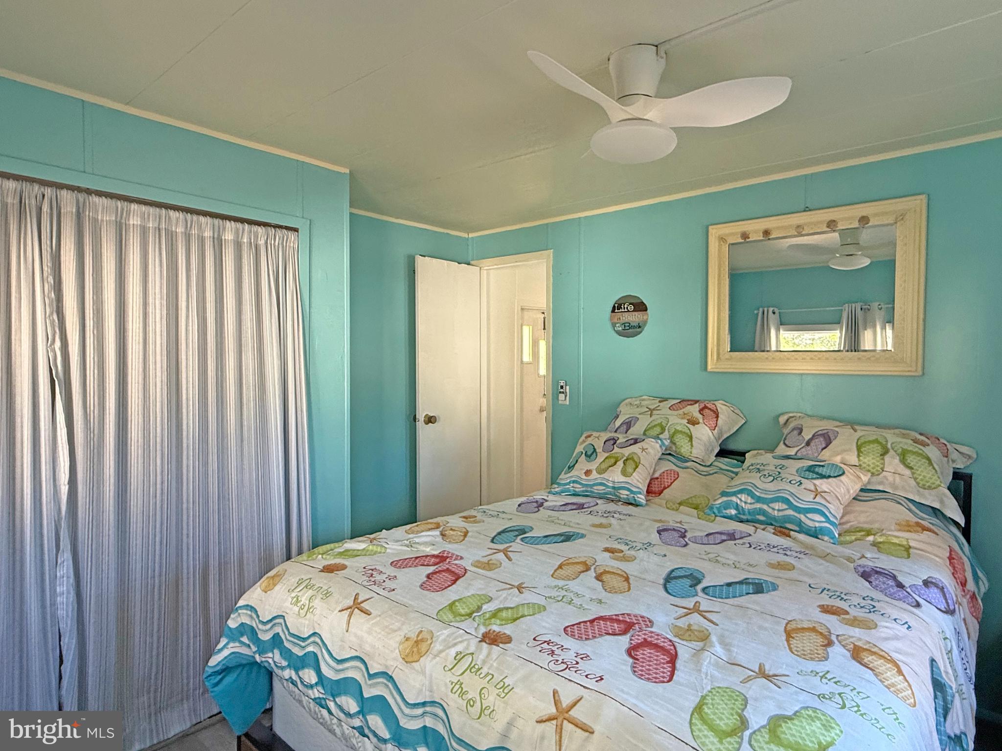 38306 Squirrel Road, Unit 217 Ocean View, DE 19970 - Photo 9 of 28 a bedroom with a bed and a painting on the wall