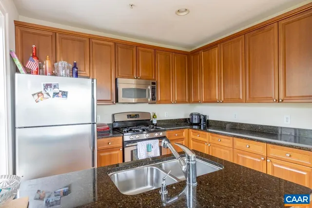 a kitchen with stainless steel appliances granite countertop a refrigerator a stove a sink and dishwasher