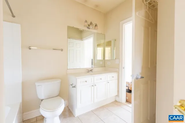 a bathroom with a granite countertop toilet a sink and a mirror