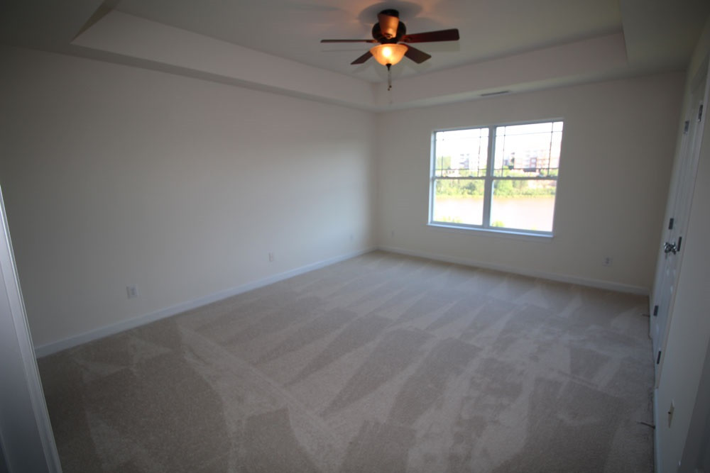 251 Broadgait Brae Road Cary, NC 27519 - Photo 13 of 25 Spacious Master Suite with beautiful lake view, tray ceiling, NEW carpet, large walk-in-closet & ceiling fan. Master Bedroom