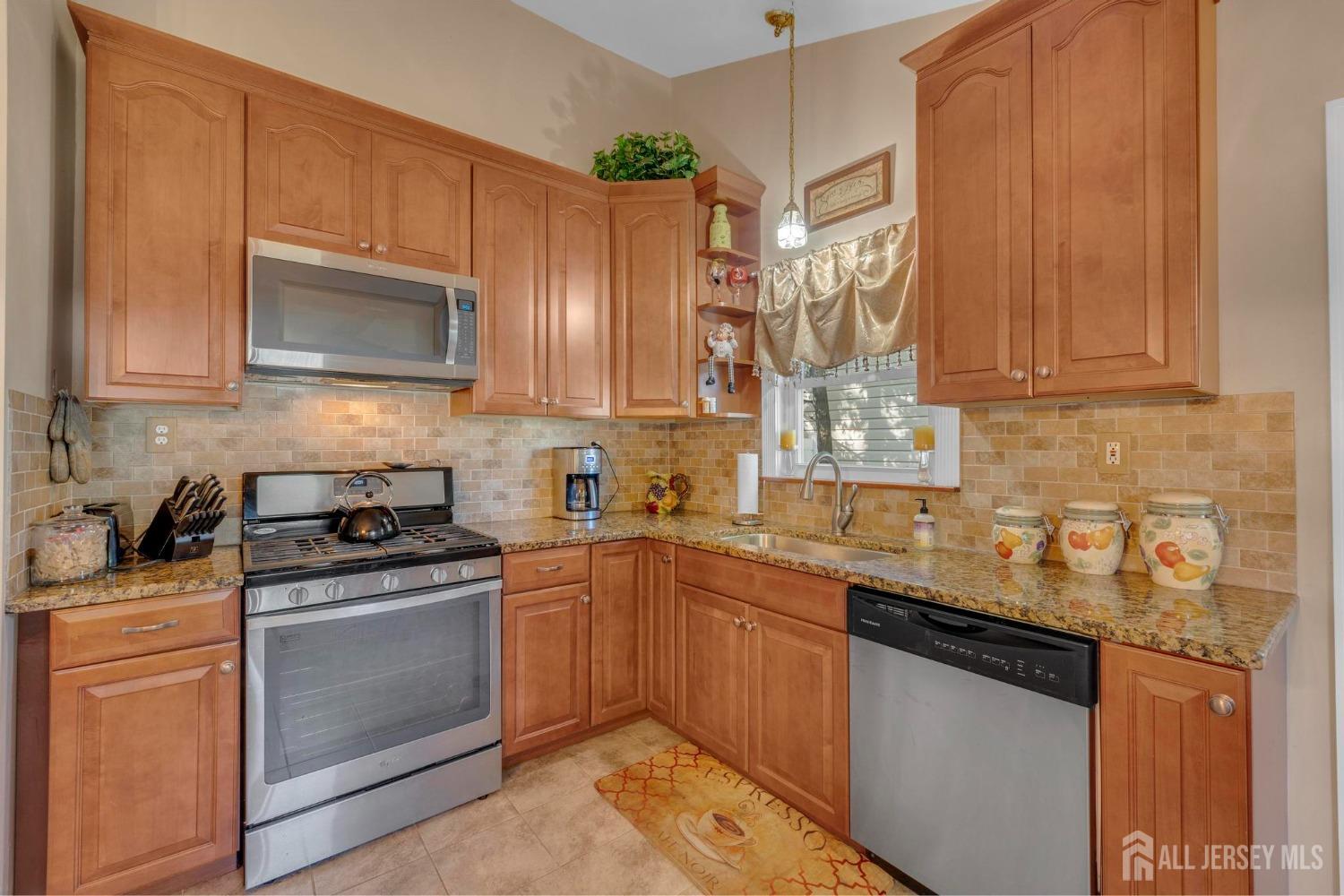 77 Albemarle Road Colonia, NJ 07067 - Photo 12 of 30 a kitchen with stainless steel appliances granite countertop wooden cabinets granite counter tops and a hard wood floors