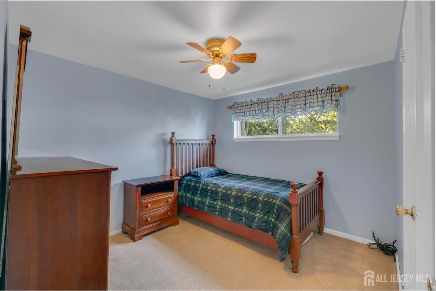 77 Albemarle Road Colonia, NJ 07067 - Photo 18 of 30 a bedroom with a bed and a chandelier