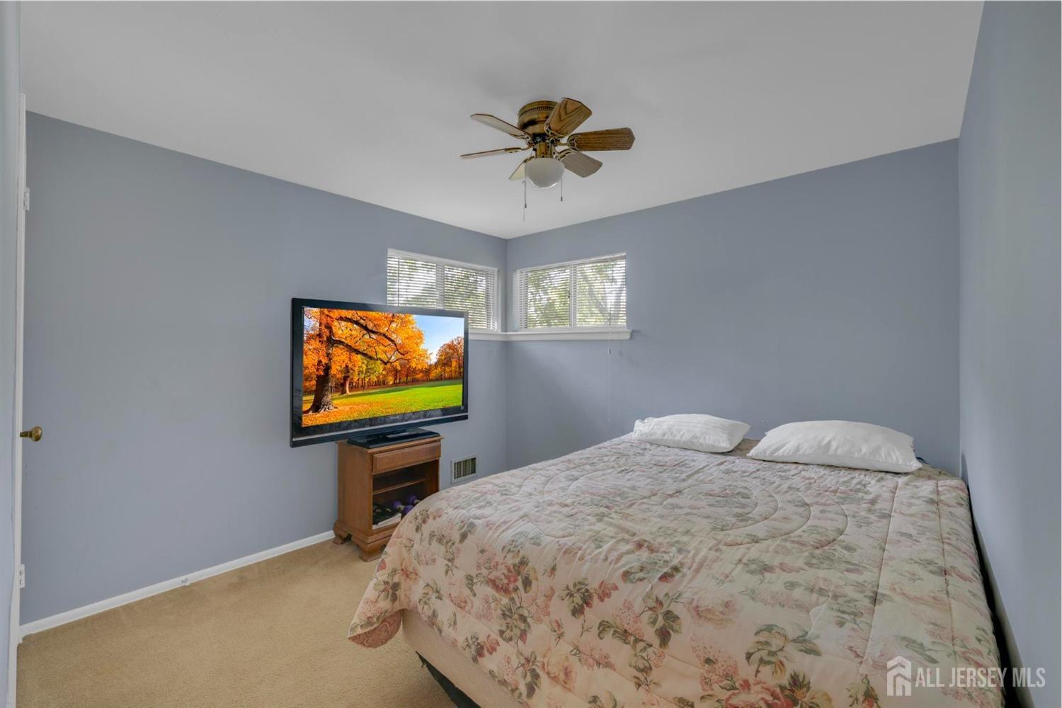 77 Albemarle Road Colonia, NJ 07067 - Photo 19 of 30 a bedroom with a bed and a flat screen tv