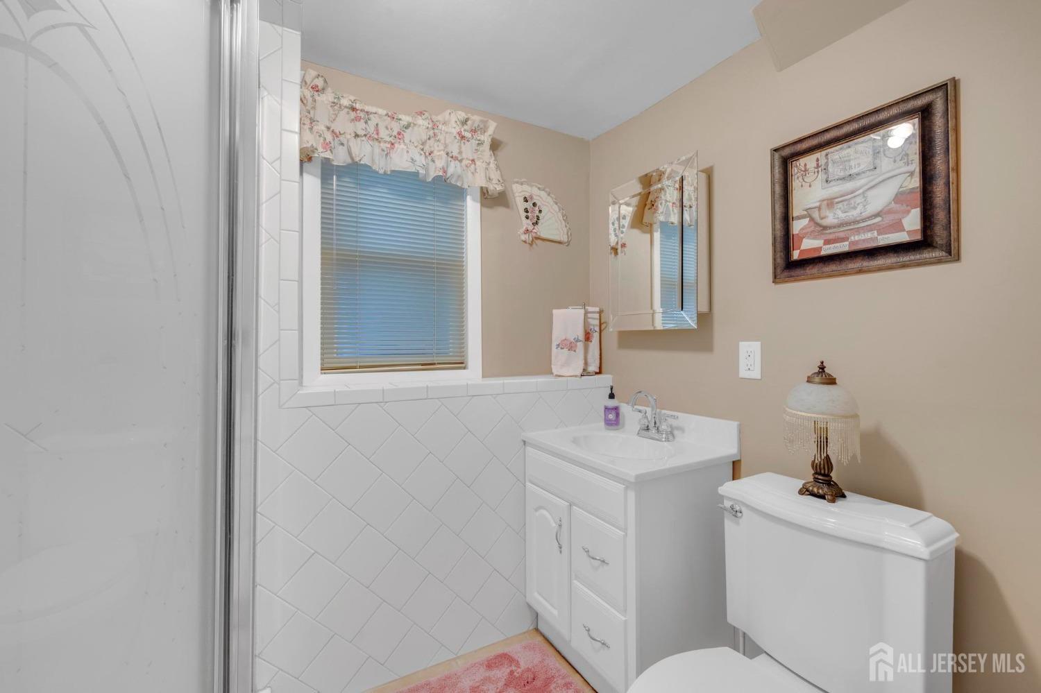 77 Albemarle Road Colonia, NJ 07067 - Photo 26 of 30 a bathroom with a sink mirror and toilet