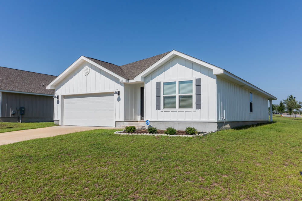 202 Laurel Hill Street Crestview, FL 32539 - Photo 2 of 25 a front view of a house with a yard and garage
