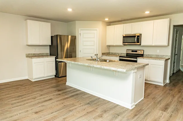 a kitchen with stainless steel appliances a refrigerator stove microwave and sink