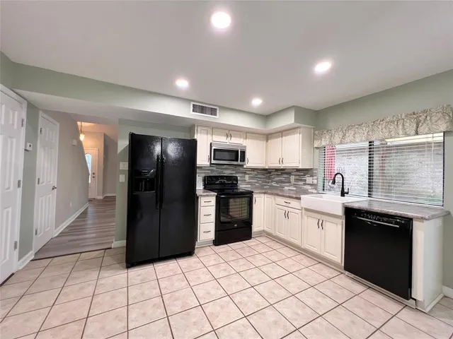 a kitchen with stainless steel appliances kitchen island granite countertop a refrigerator and a sink