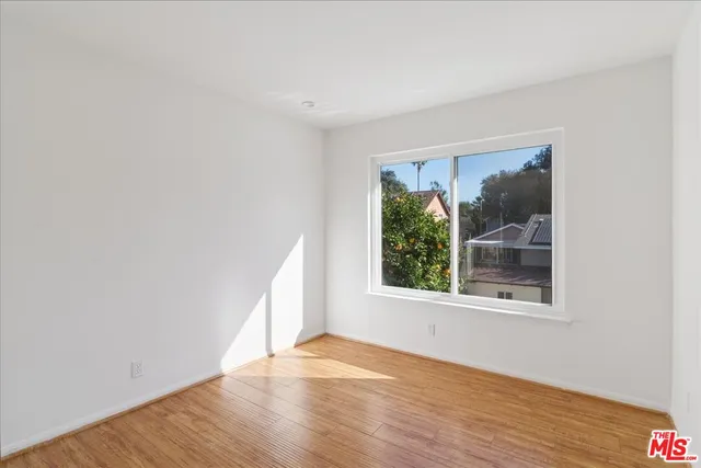 a bedroom with a bed chandelier and a window