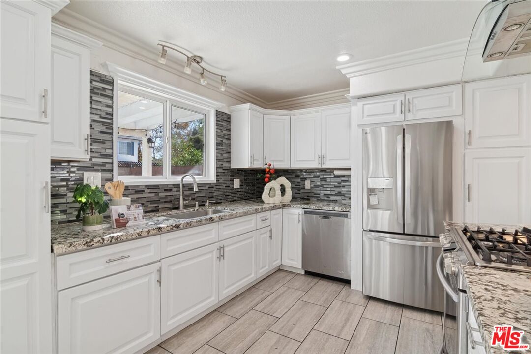 2216 Carlsbad Court Simi Valley, CA 93063 - Photo 9 of 32 a kitchen with a refrigerator a sink and wooden cabinets