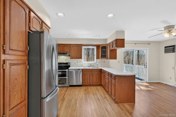a kitchen with stainless steel appliances granite countertop a refrigerator a stove and a wooden floors